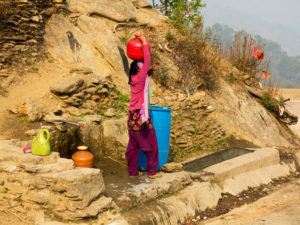 A woman fetches water from a spring at Tula Kote village in the Kumaon hills, Uttarakhand