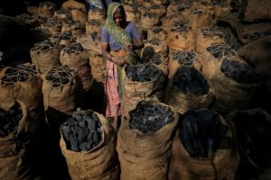 <p>Woman loading charcoal in Ahmedabad, Gujarat, India. There will be little progress in combating climate change at COP26 unless millions of people are helped to move away from their dependence on the fossil fuel economy. (Image: Alamy) </p>