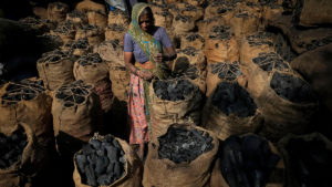 Woman charcoal Ahmedabad Gujarat India climate change fossil fuel coal economic growth and job security