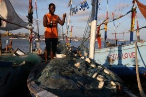 Ghana fisher mending nets