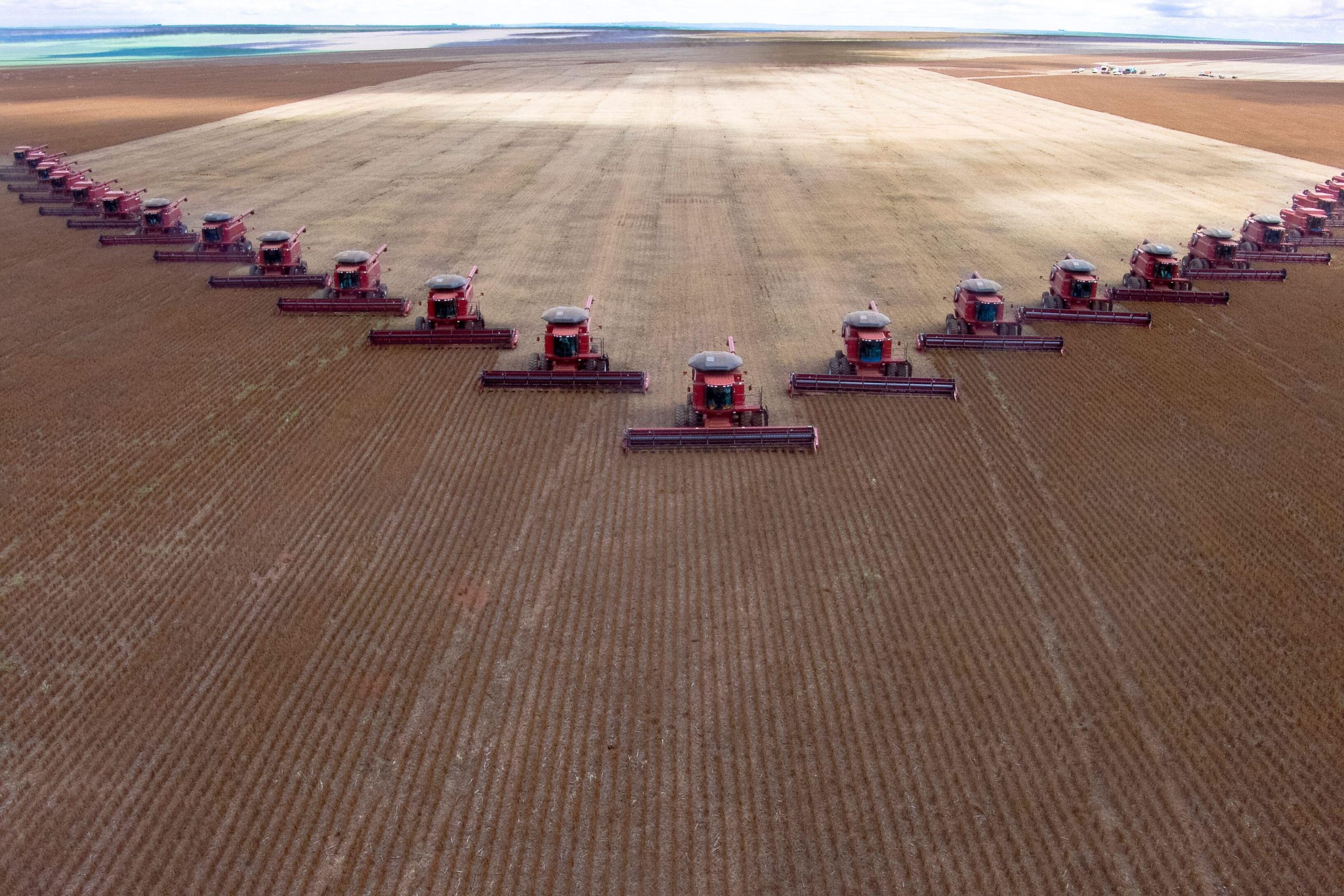 Aerial view of harvesters in a V formation in soybean field