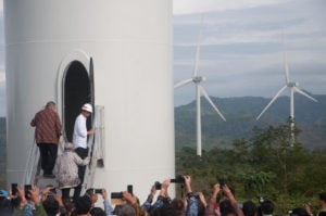 Indonesia President Joko Widodo inaugurates a wind farm in front of a crowd taking photos