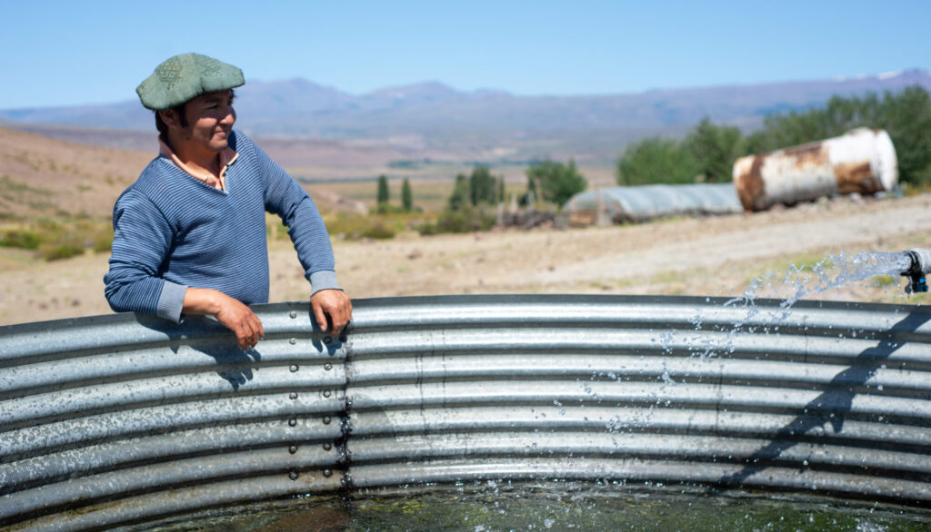 A farmer in front of a pool in a field