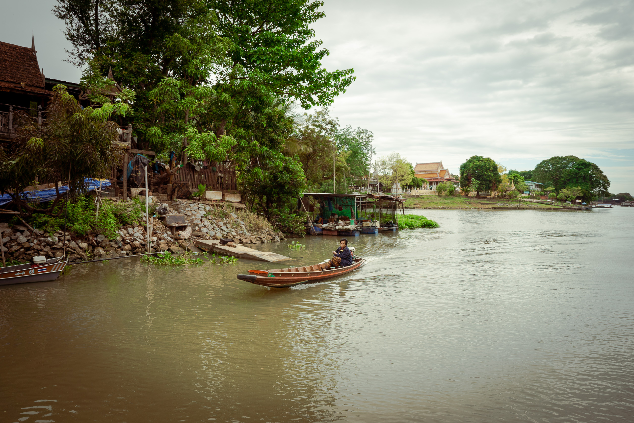 person in small boat on murkey river
