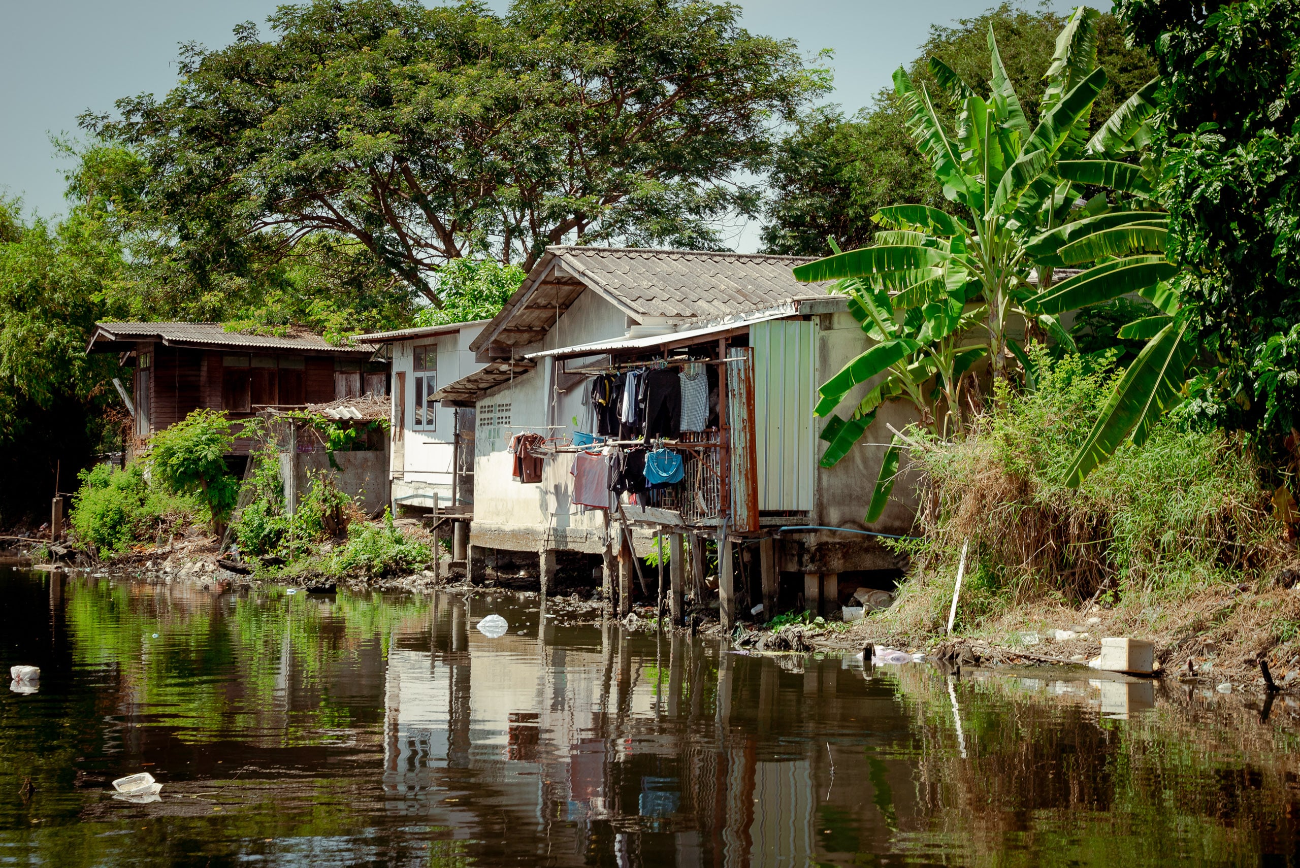clothes hanging out to dry from balcony of house on stilts on riverside