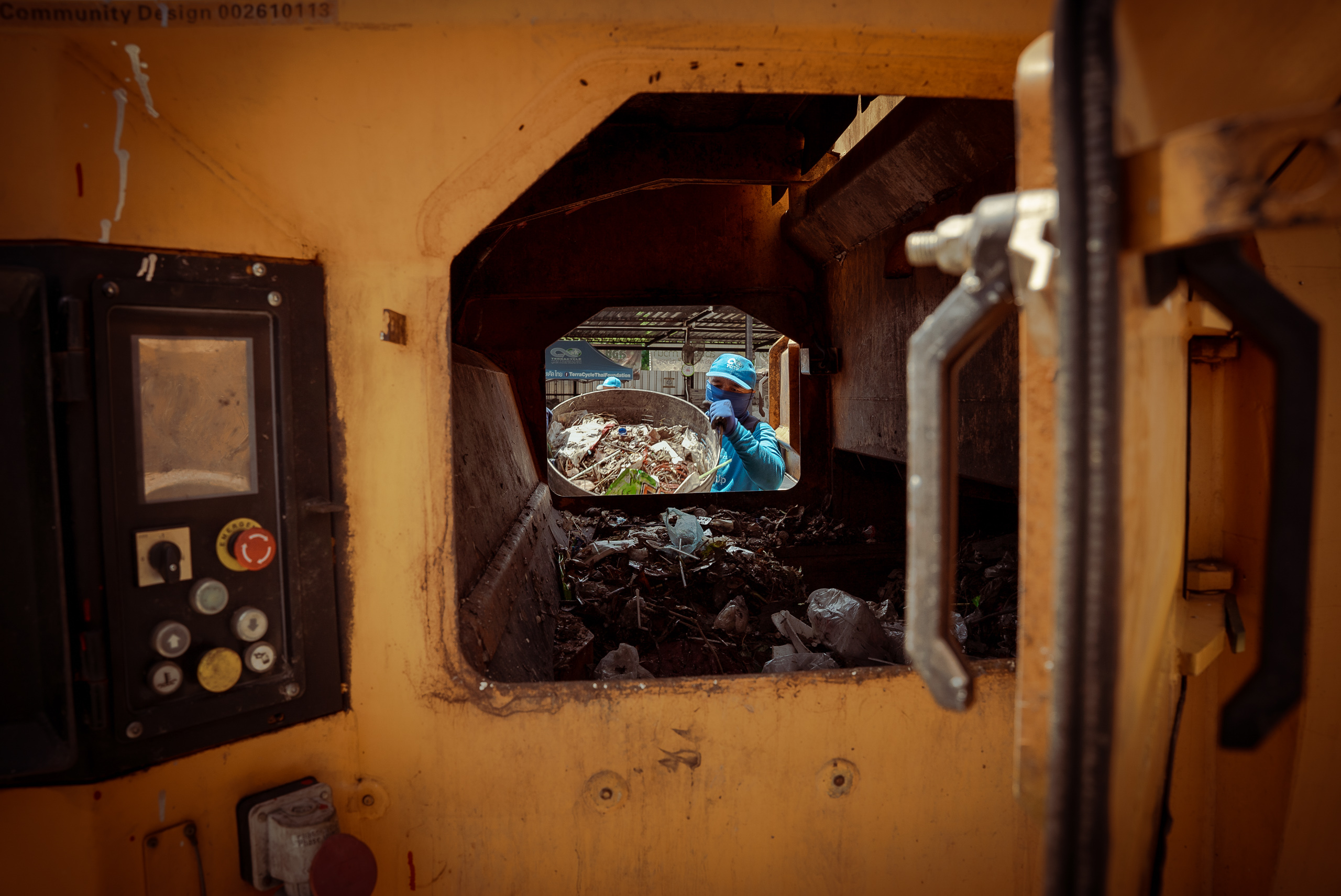 man throwing basket of waste into incinerator