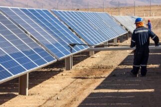 Un trabajador limpia paneles solares en el desierto de Atacama, Chile