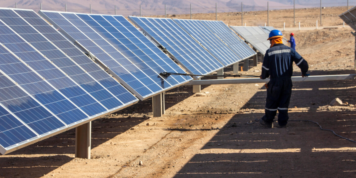 <p>Un trabajador limpia paneles solares en el desierto de Atacama. Chile ha tenido notables éxitos en el aumento de la capacidad de energía renovable en los últimos años, pero, como muchos países en América Latina, todavía se enfrenta a obstáculos financieros y políticos en la transición para abandonar los combustibles fósiles. (Imagen: Francisco Javier Ramos Rosellon / Alamy)</p>