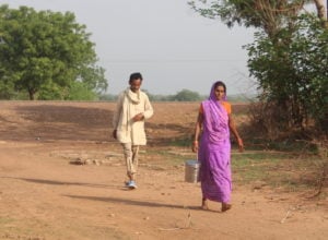 <p>Kamlawati Yadav delivers milk with her husband, Raghunandan. Uneven rainfall, few amenities and a tough geography makes fetching water – a task largely borne by women – difficult in India’s Bundelkhand region. (Image: Jigyasa Mishra)</p>