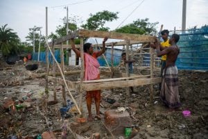 people putting up wooden frame for building