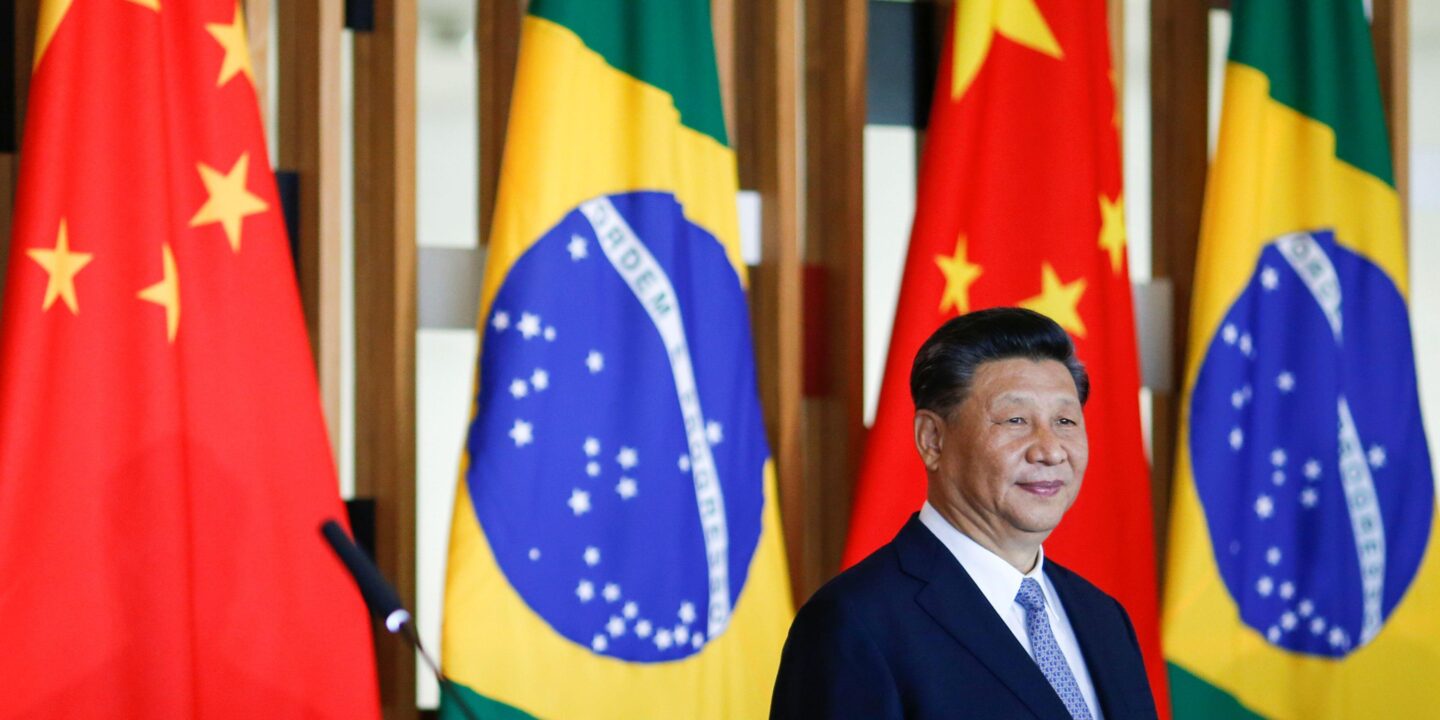 Xi Jinping at an event in front of the flags of Brazil and China
