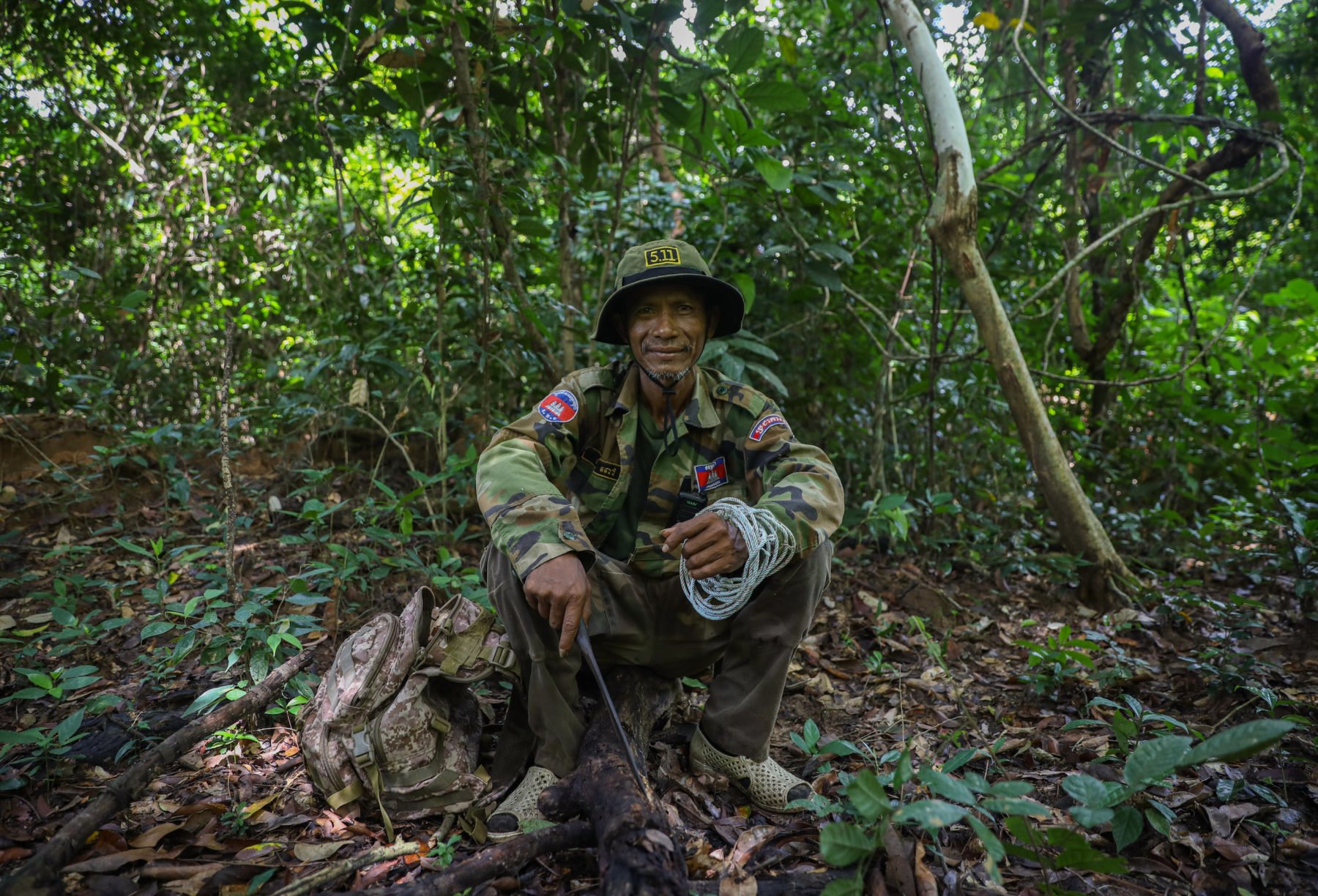 man sitting on tree stump in forest