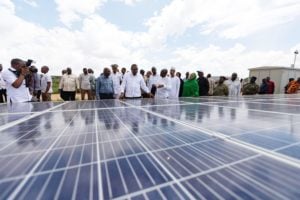 group of people gathered around ground level solar panels