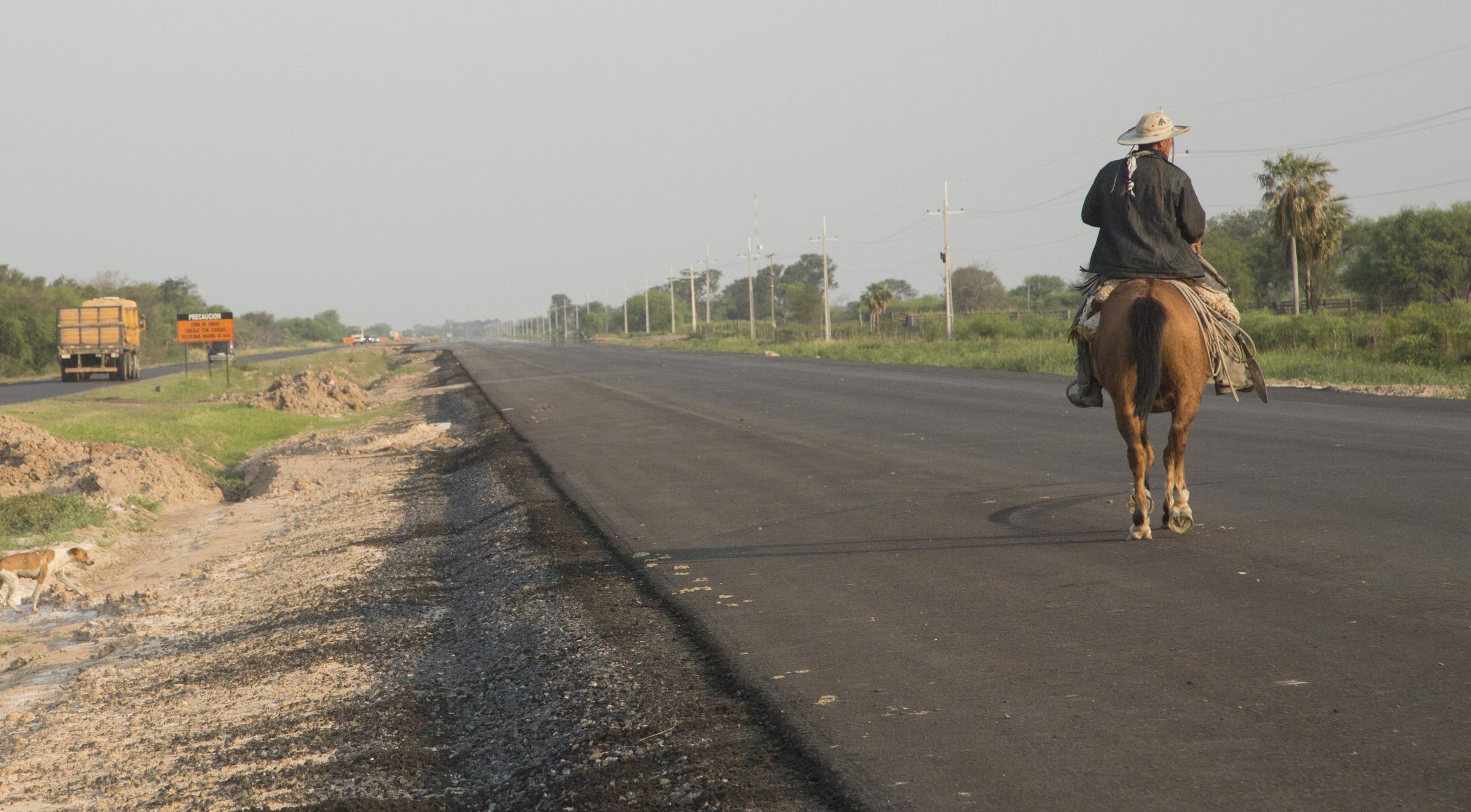 <p><span style="font-weight: 400;">A cattle farmer rides along a nearly completed section of the Bioceanic Corridor, a project seeking to improve connectivity through Paraguay’s Gran Chaco (Image: Santi Carneri/Diálogo Chino)</span></p>