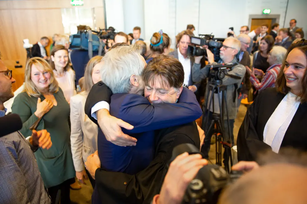 two men hugging surrounded by crowd