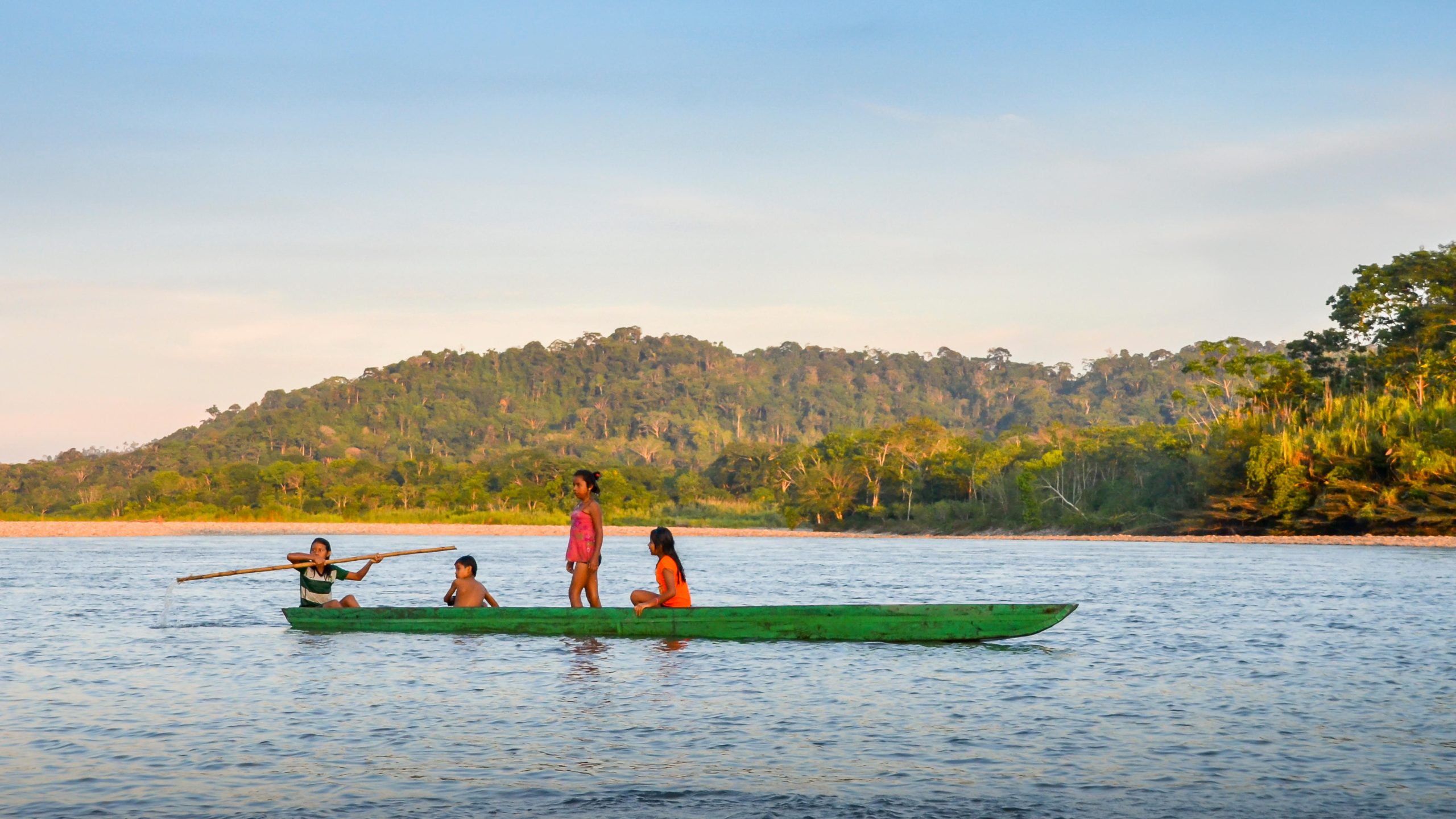 cuatro jóvenes en una canoa en un río