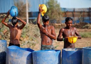 <p>Workers at a construction site on the outskirts of Ahmedabad, India, try to cool themselves during the record-breaking heatwave earlier this year (Image: Amit Dave / Alamy)</p>