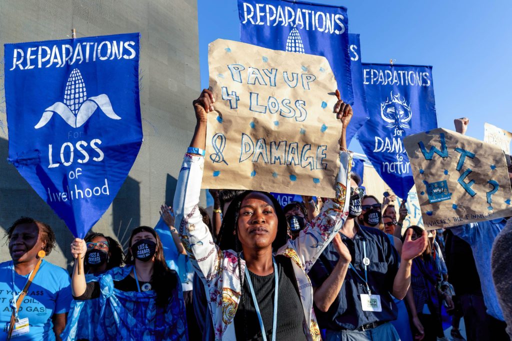 people holding up signs asking for Loss and Damage reparations