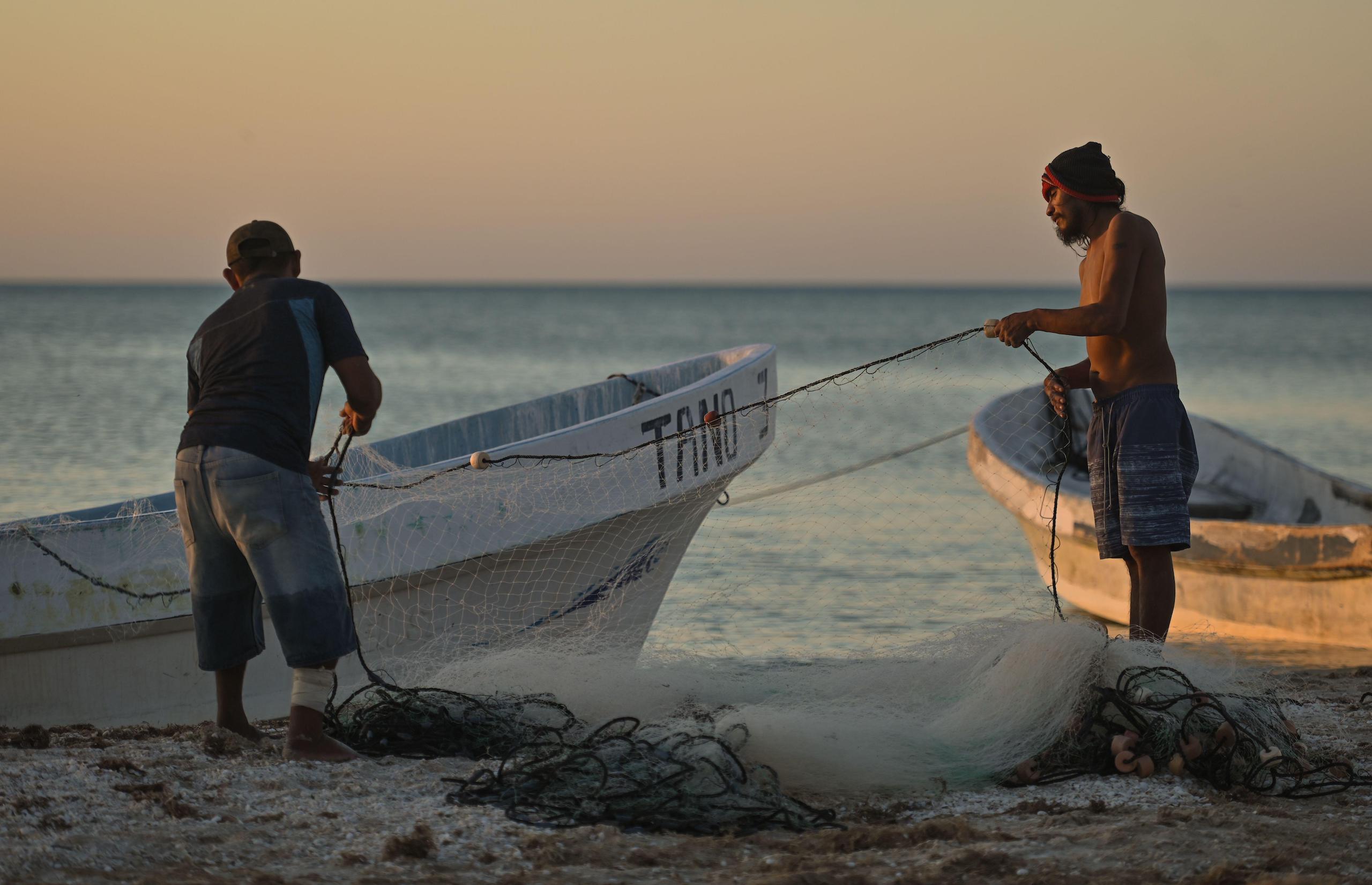 Men prepare their nets before a fishing trip in Celestun, Mexico
