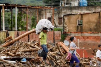 <p>Una persona carga sus pertenencias tras las inundaciones provocadas por las fuertes lluvias en Las Tejerías, Venezuela, en octubre de 2022 (Imagen: Leonardo Fernández Viloria / Alamy)</p>