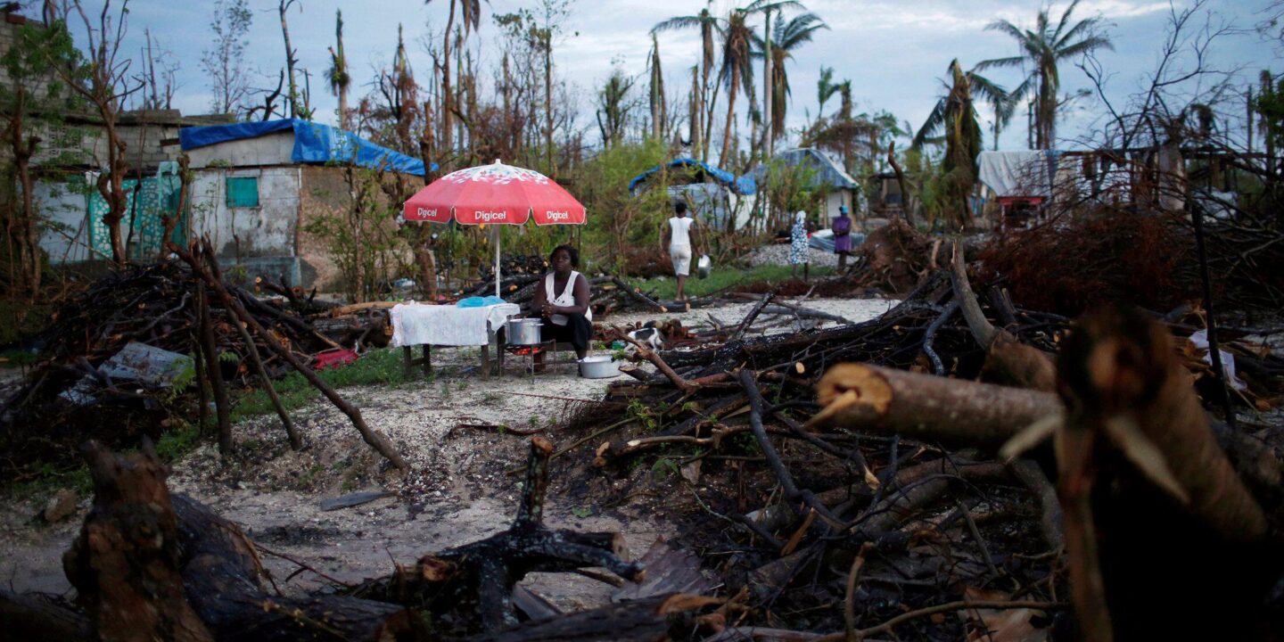 <p>Una vendedora de alimentos trabaja en medio de los daños provocados por el huracán Matthew en Haití, en octubre de 2016. La financiación de las pérdidas y los daños causados por el cambio climático ha sido el tema más polémico de la cumbre COP27 (Imagen: Carlos García Rawlins / Alamy)</p>