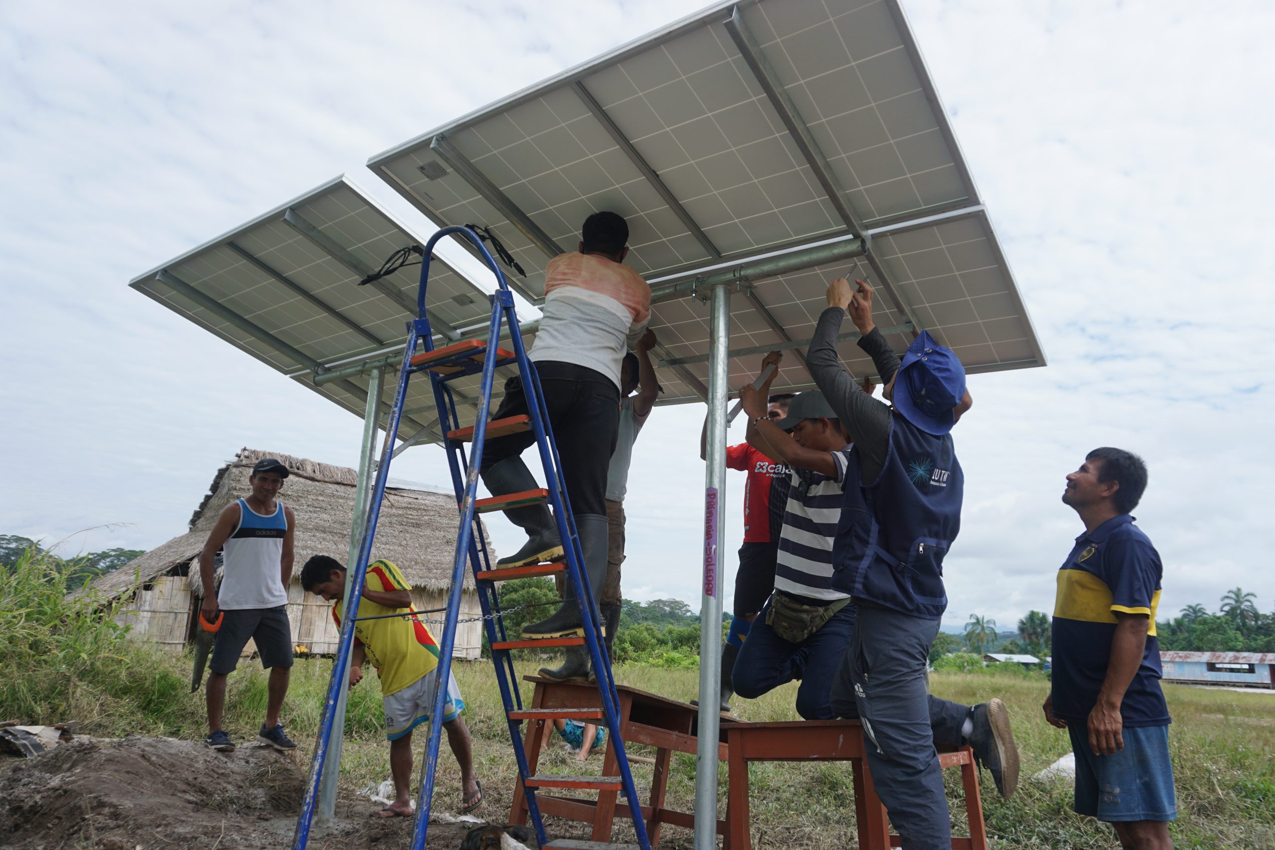 People work on the installation of a solar panel in a community in the Peruvian Amazon