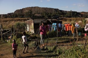 <p>南非姆普马兰加省的埃马拉赫莱尼，一名女性和她孩子们，其身后是一座废弃的煤矿。图片来源：Alamy / Siphiwe Sibeko</p>