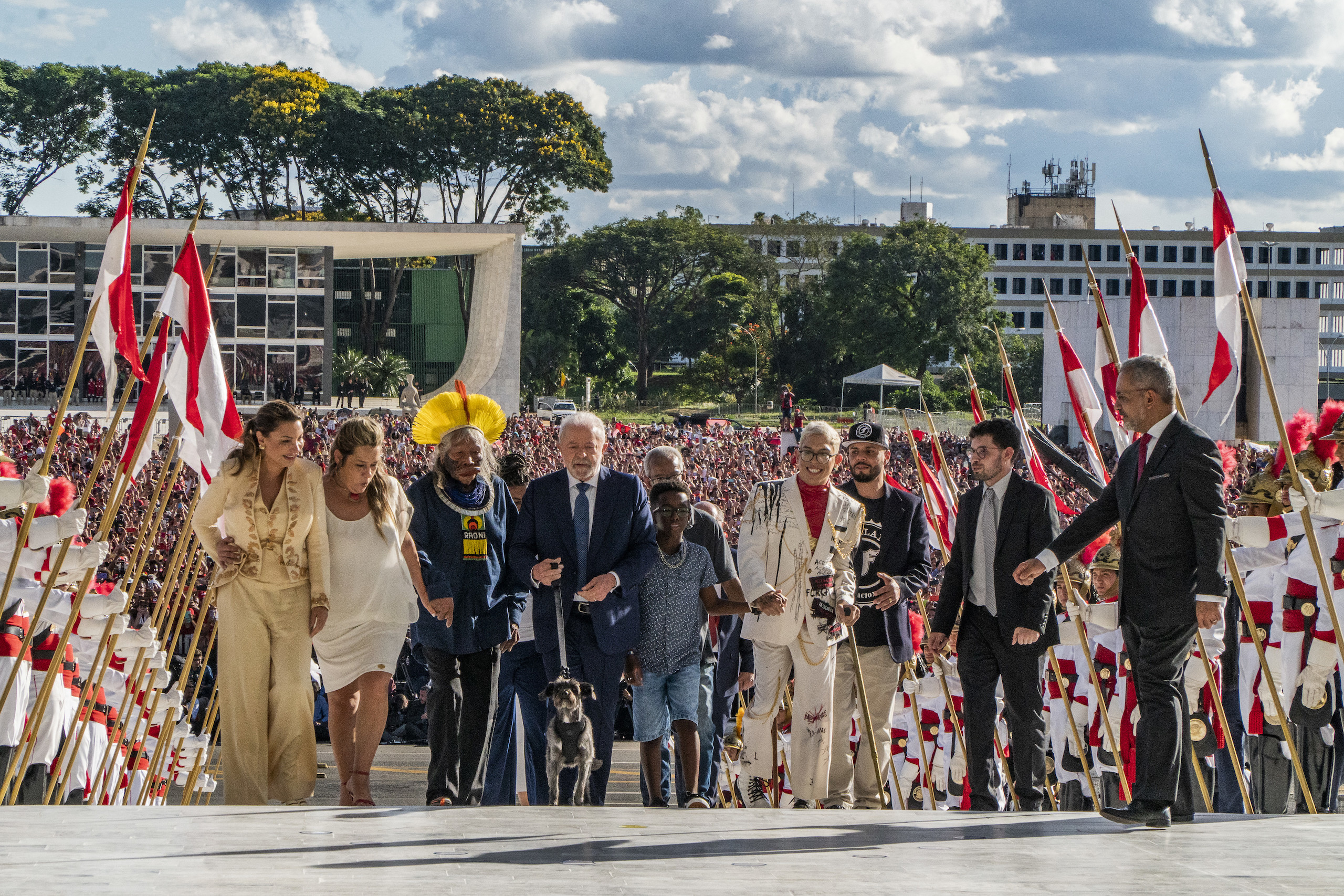 Brazilian president Lula walks up steps on the day of his inauguration, crowd in the background