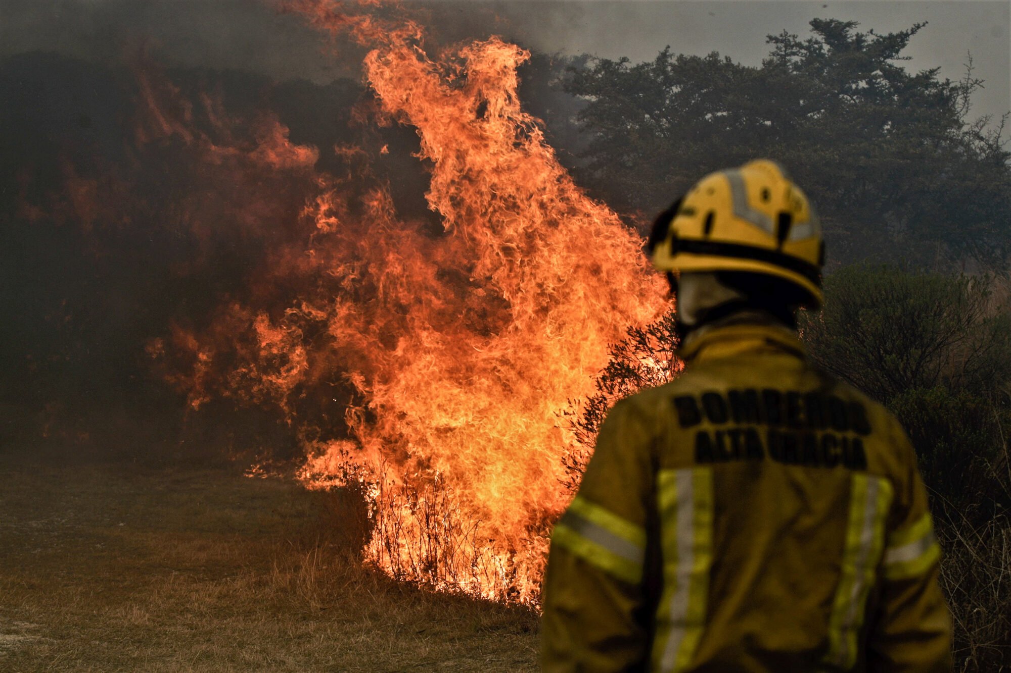 A firefighter stands in front of a wildfire in Cordoba, Argentina in 2020