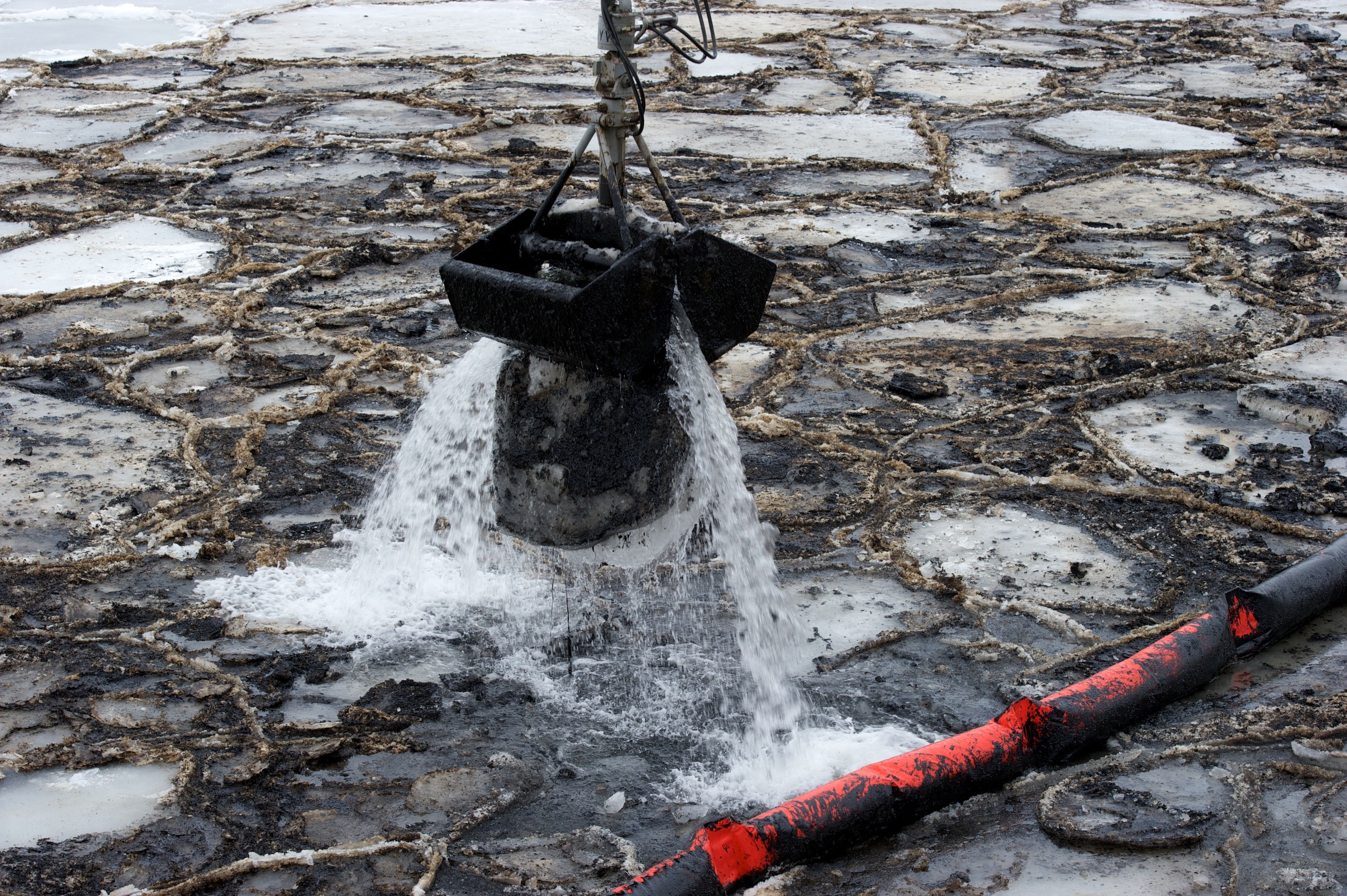 : A red boom is used to try and limit the spread of heavy fuel oil across the ocean surface. 