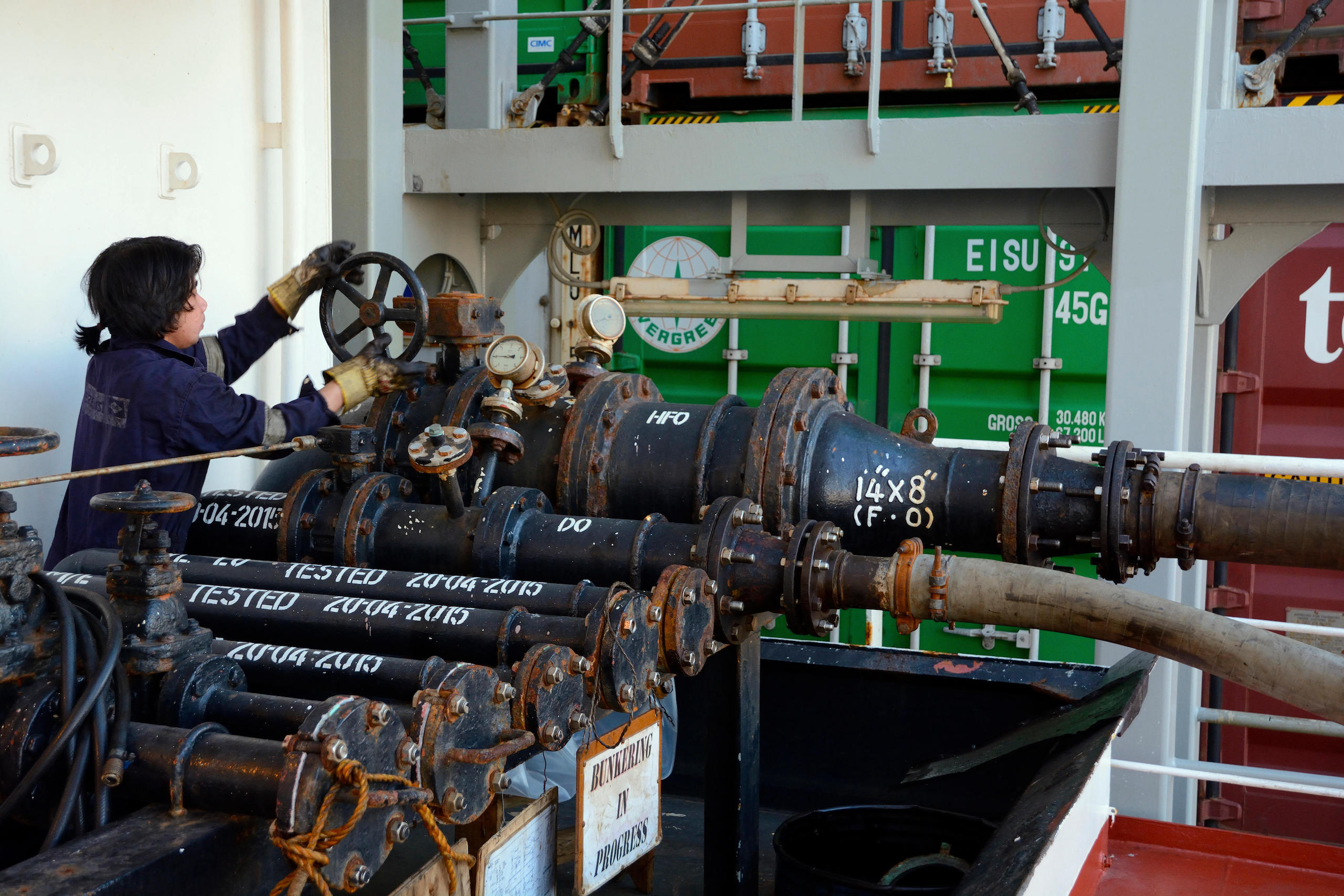A sailor filling a cargo ship with bunker oil - which produces black carbon when burned as a fuel for ships