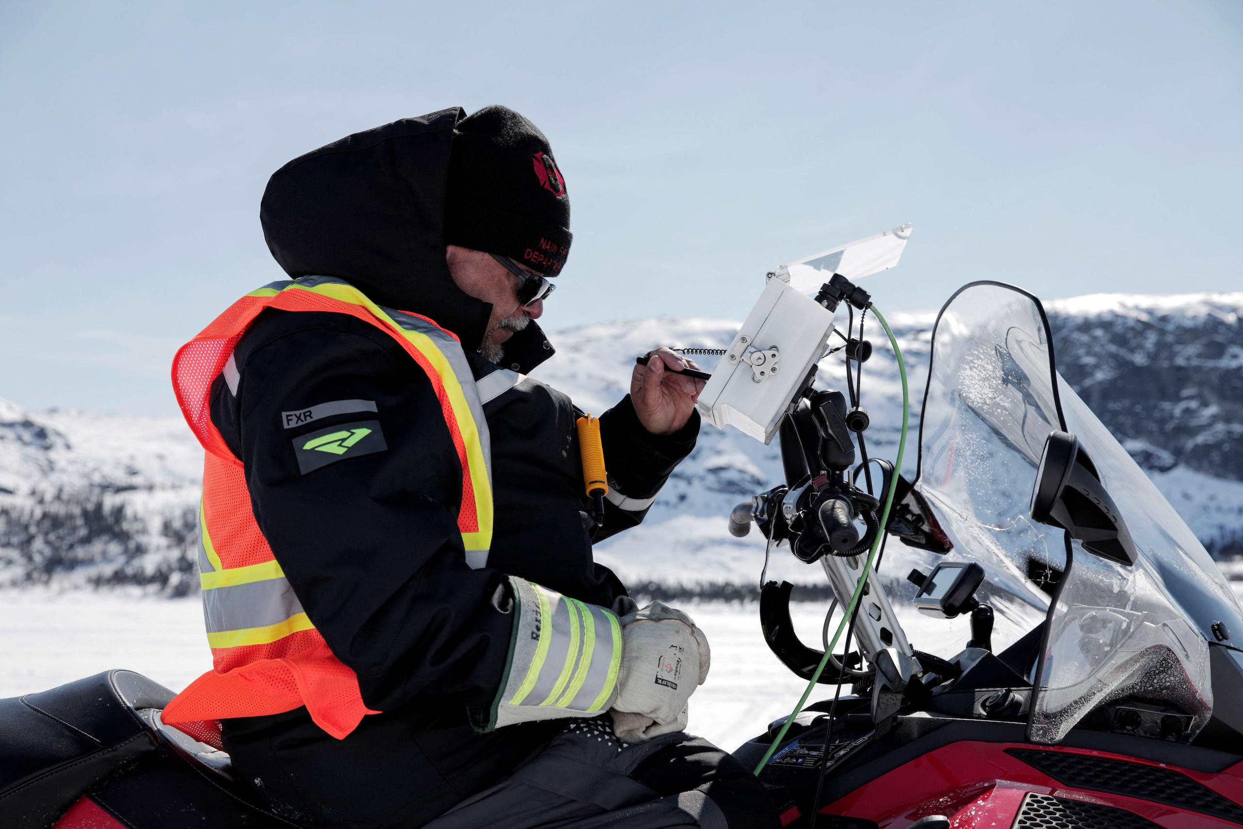 An Inuit resident of Nain Bay, Canada checks real-time measurements of sea ice thickness along ice highways.