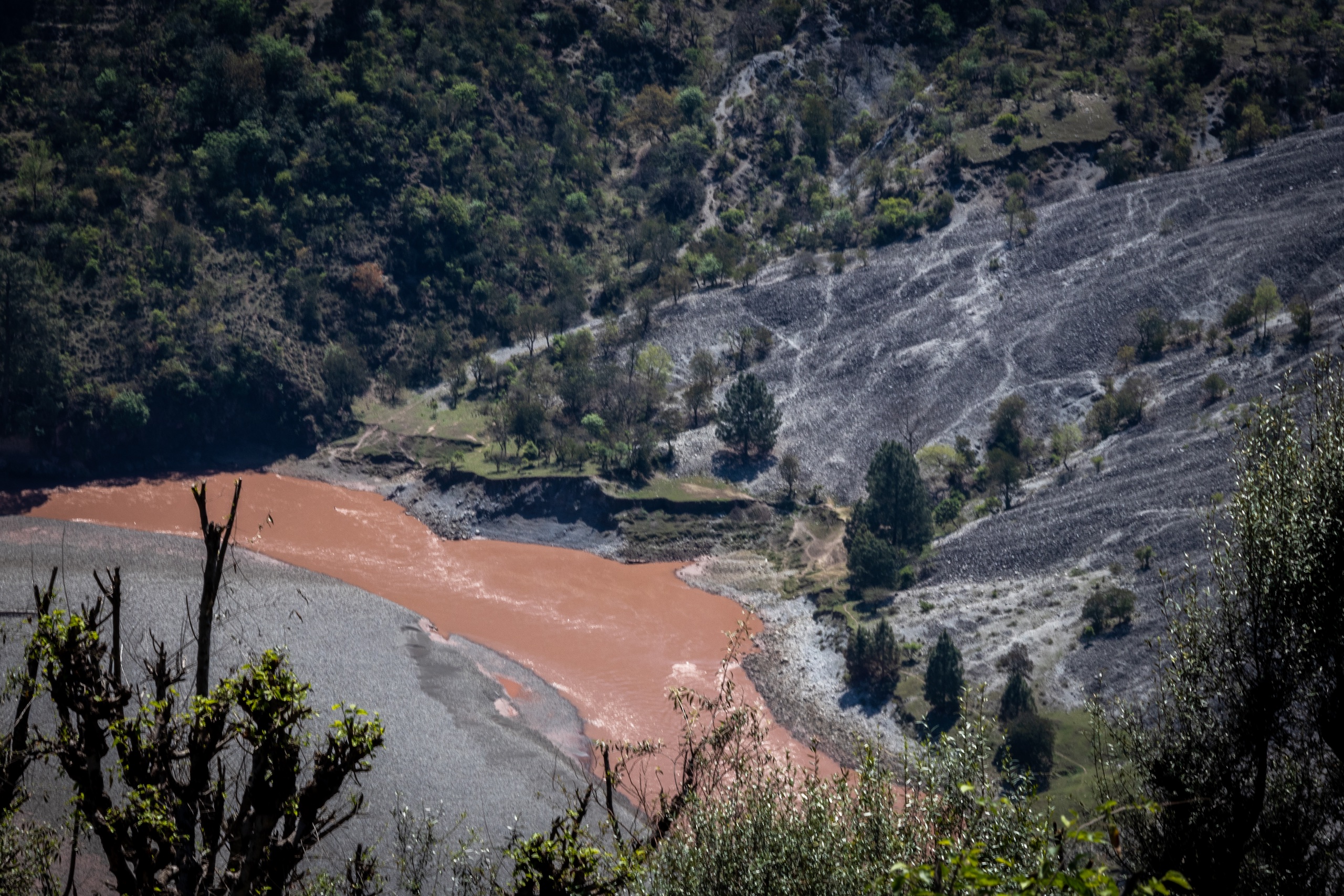 Photographs showing sediments mixed with Chenab river and its tributaries due to the construction of the Chenab Rail Bridge. The dumping of debris has led to the contamination of the water of the Chenab river which is used for drinking and other activities.