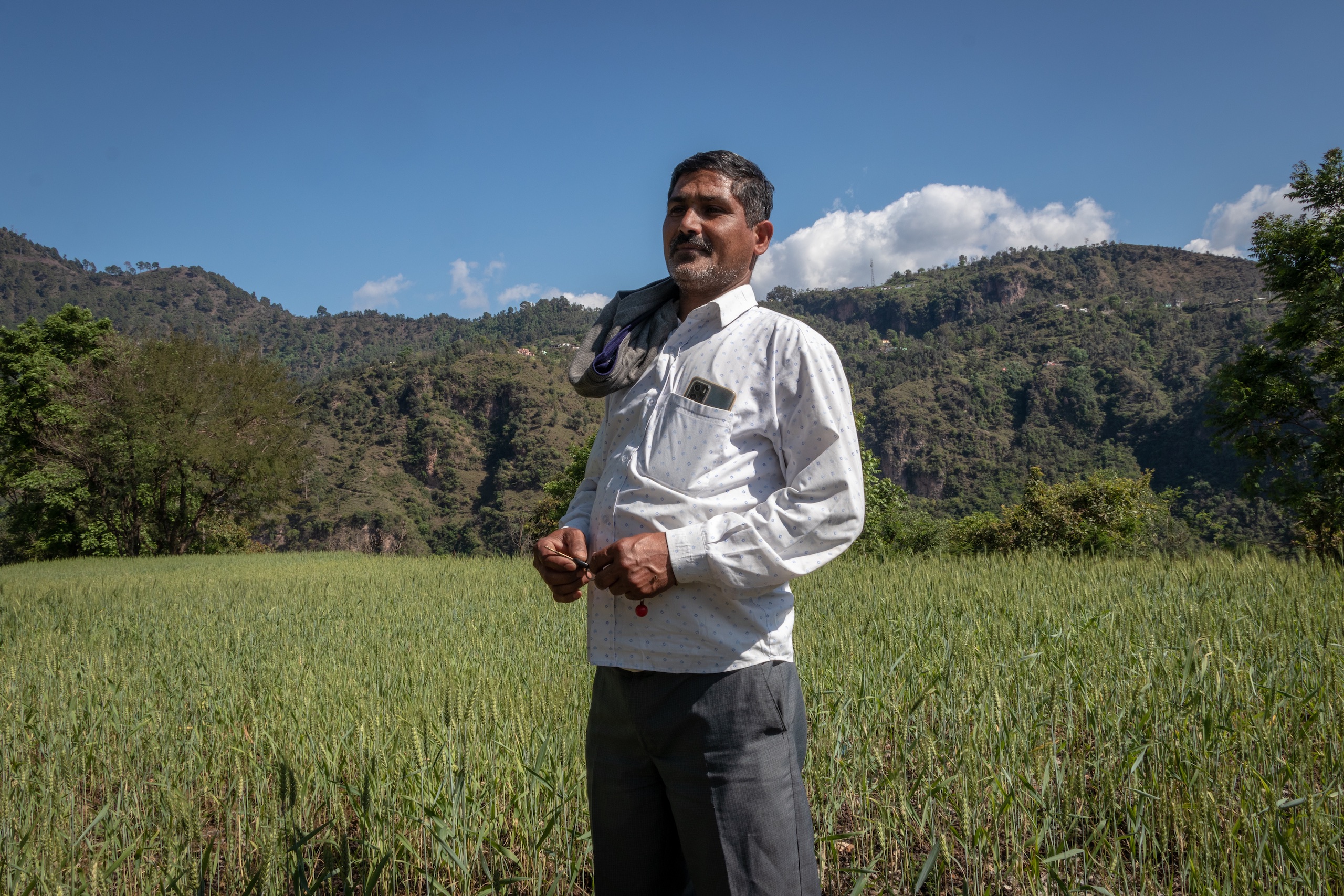 Ravi Das, 47, a resident of Salal village in Reasi district, Jammu and Kashmir stands in his agricultural field which he believes will be taken away after lithium mining kicks off in the coming years.