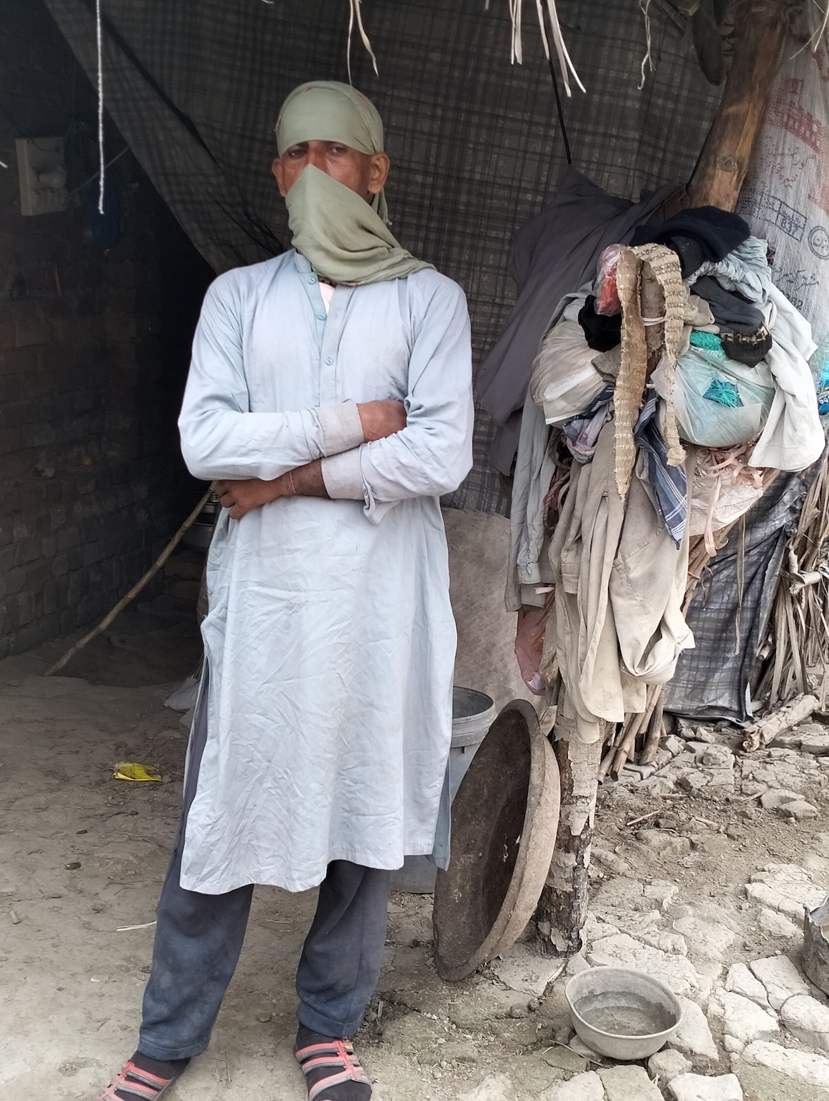 Nargis stands outside her home in Charsadda, which still bears the marks of damage from the devastating floods in August-September 2022