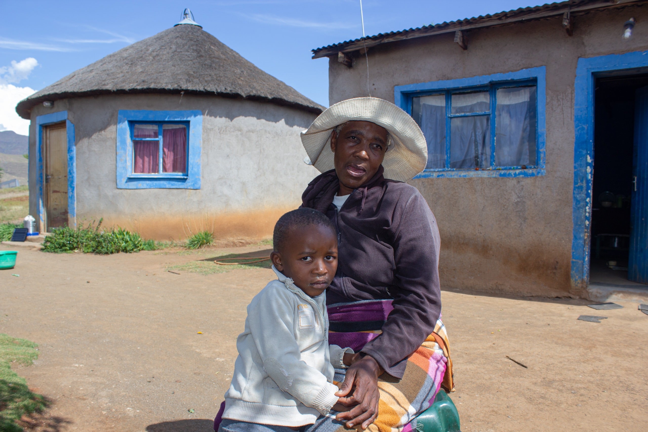 a woman and a child in front of their home