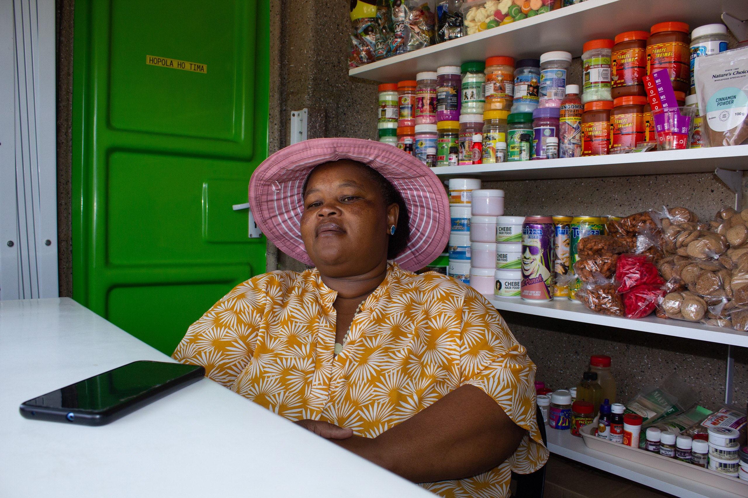 a woman sitting inside her solar charging kiosk