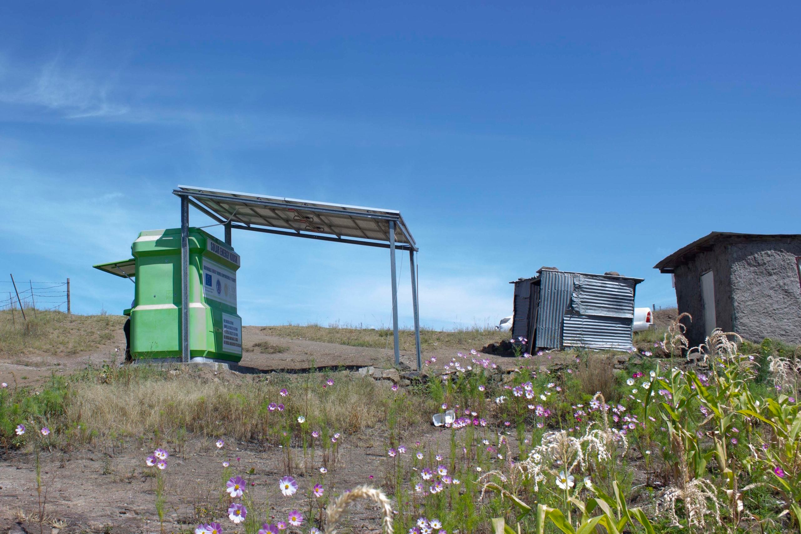 a field of wildflowers in front of the solar charging kiosk