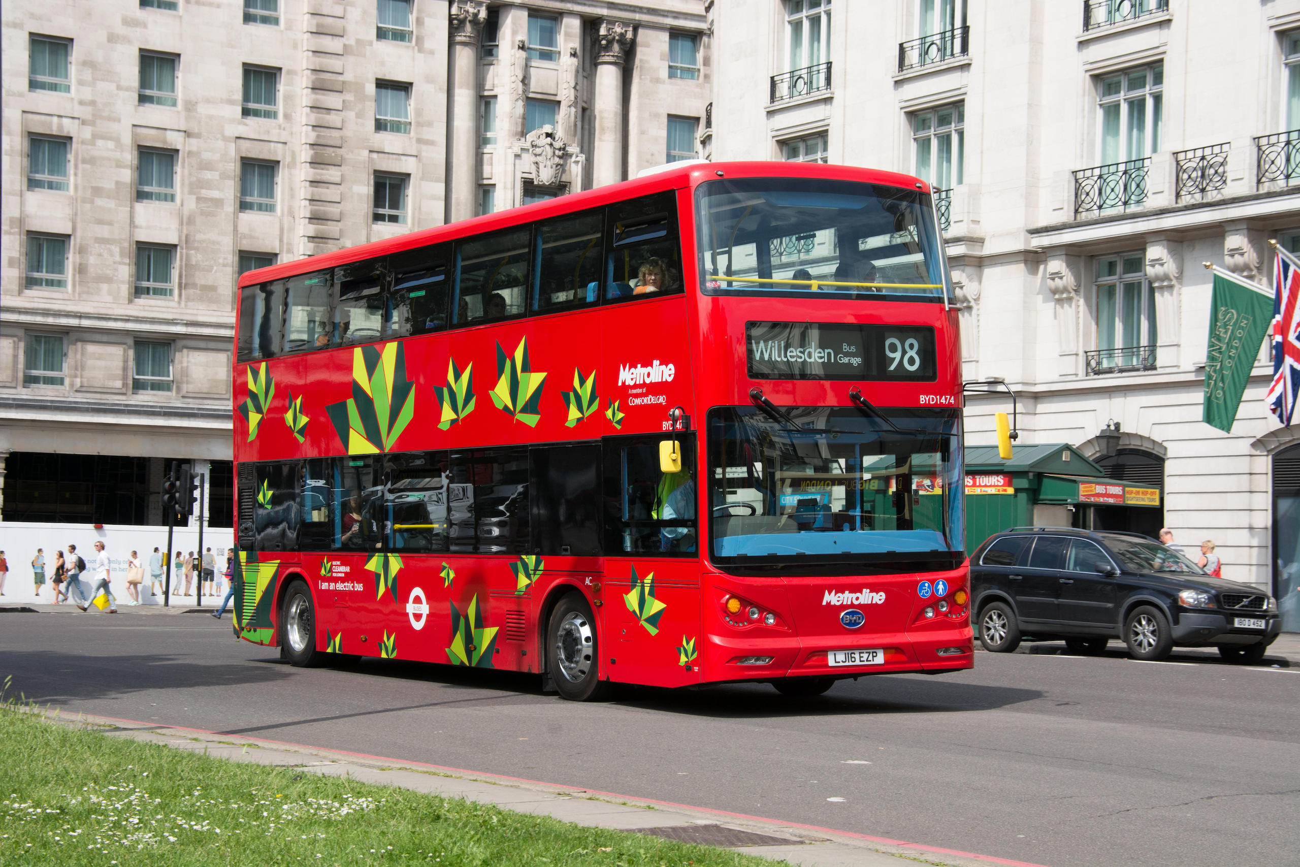 Red London double decker bus with leaf design on outside, electric vehicle made by BYD