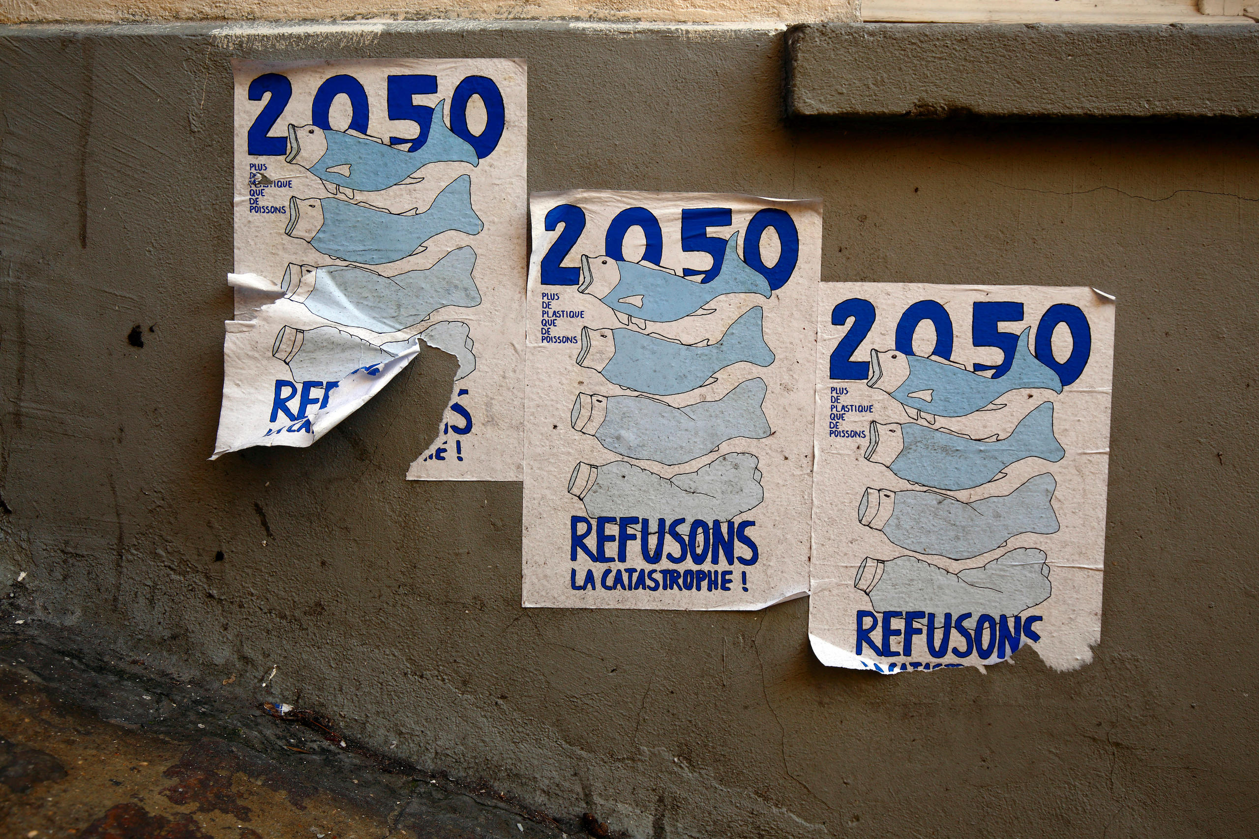 <p>在法国巴黎，一面墙上的海报上写着：“2050年：塑料将会比鱼还多。拒绝灾难！”（图片来源：Robert K. Chin / Alamy）</p>