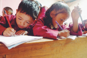 <p>Schoolchildren write in their notebooks during a lesson at a school in Nepal (Image: Alamy)</p>