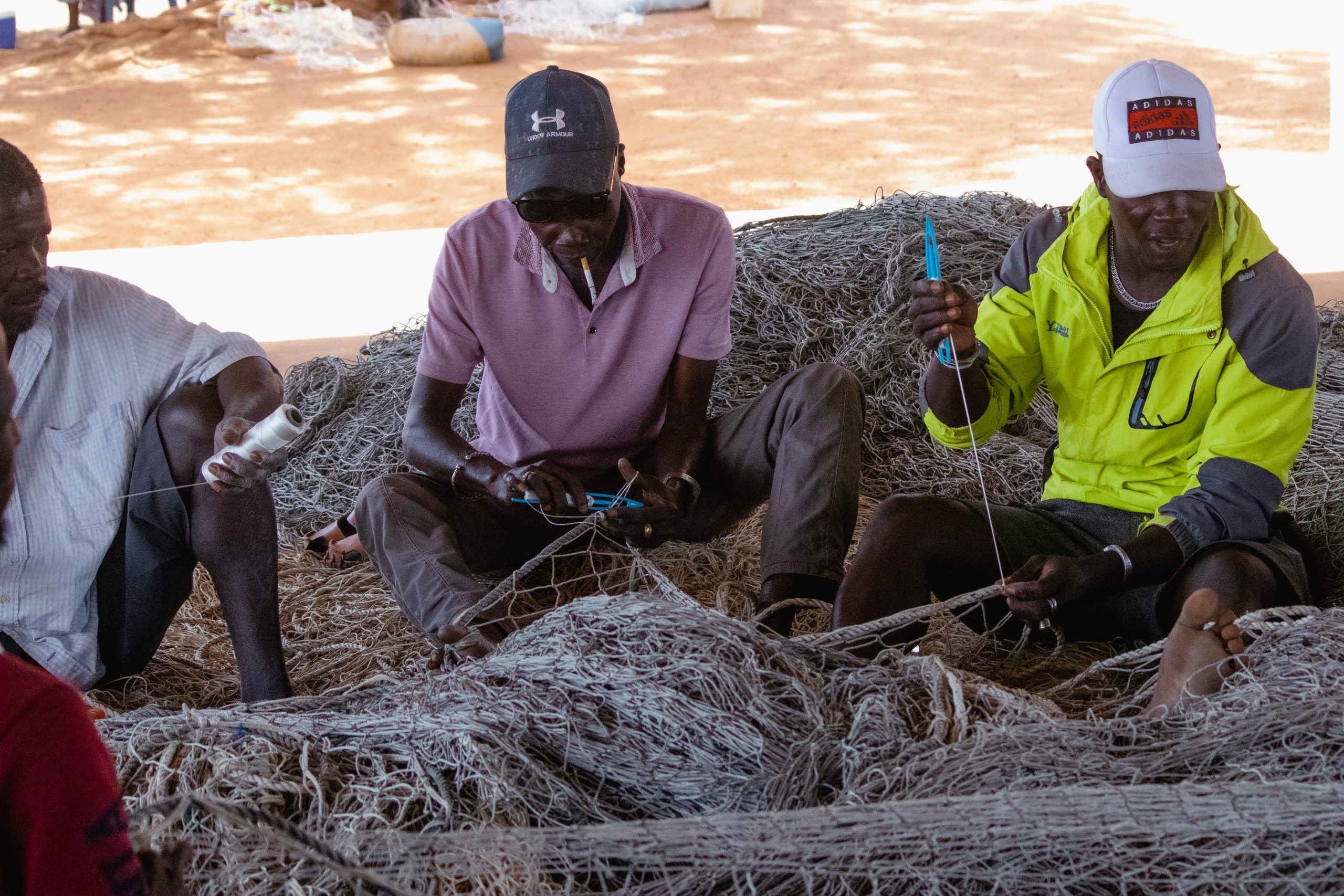 group of men untangling fishing nets