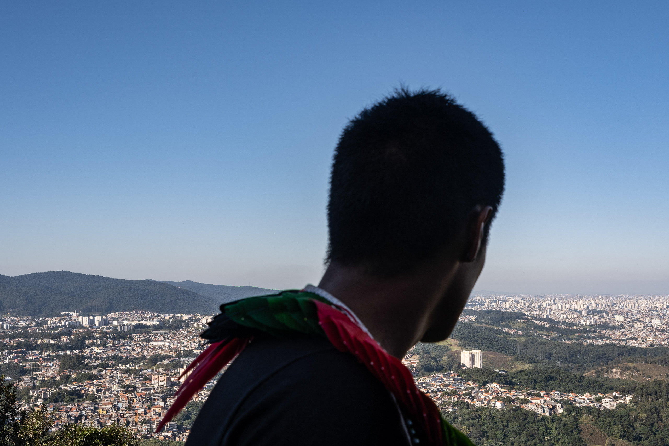 The silhouette of a man looking out at a city landscape