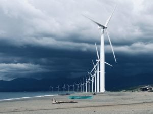 wind farm on beach under dark sky