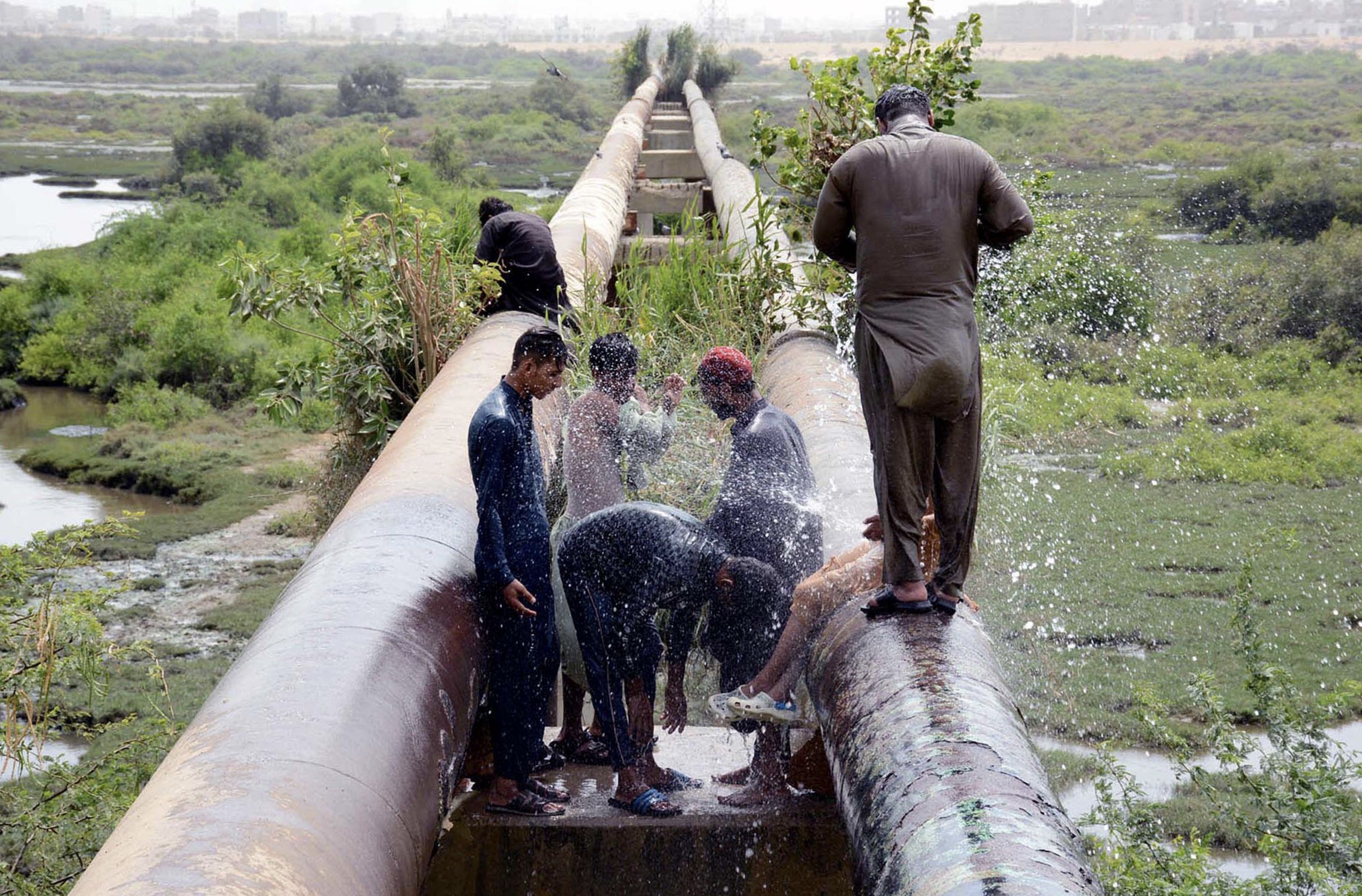 <p>People cool down along the Malir River near Karachi, the site of a planned expressway. Critics contend that the project will destroy much-needed green space. (Image: Owais Aslam Ali / Alamy)</p>