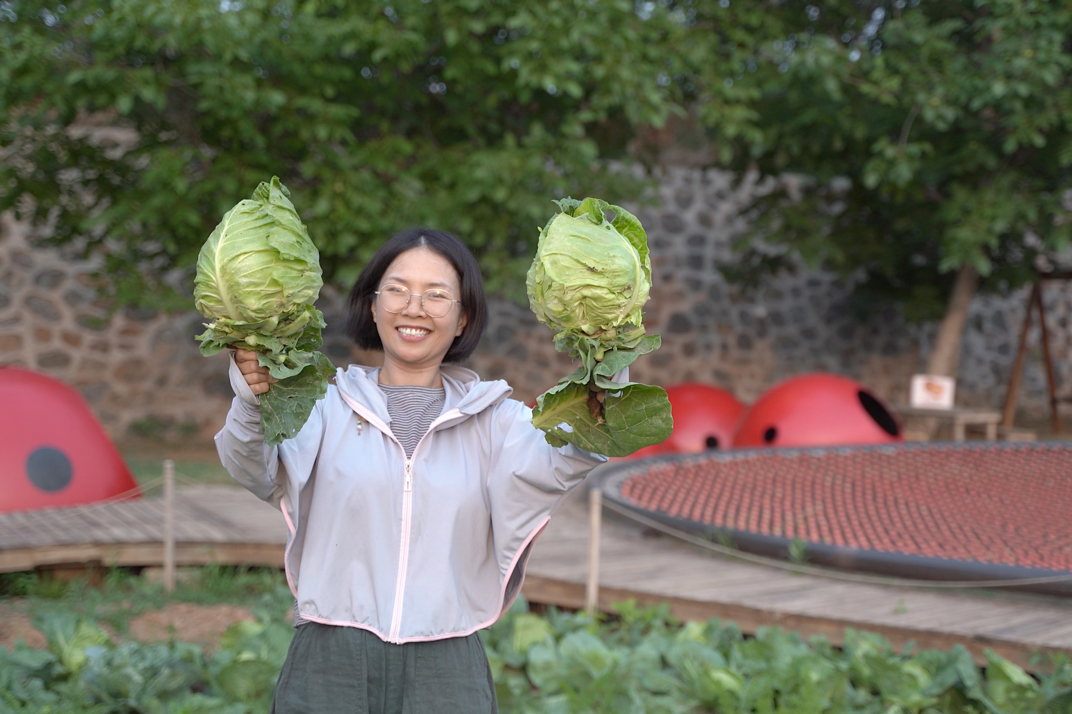 A farmer holding two cabbages 