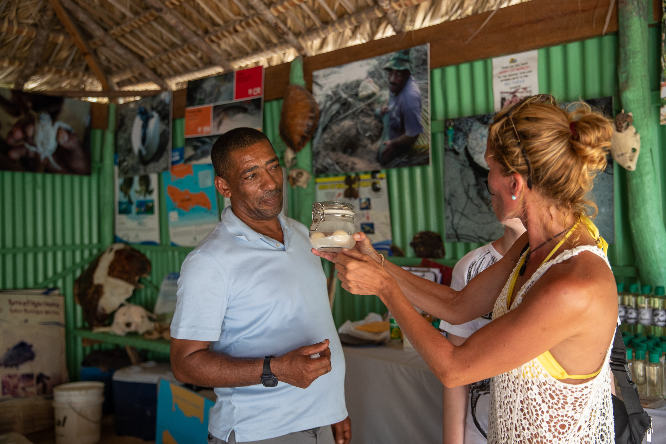 man observing woman holding small mason jar containing eggs