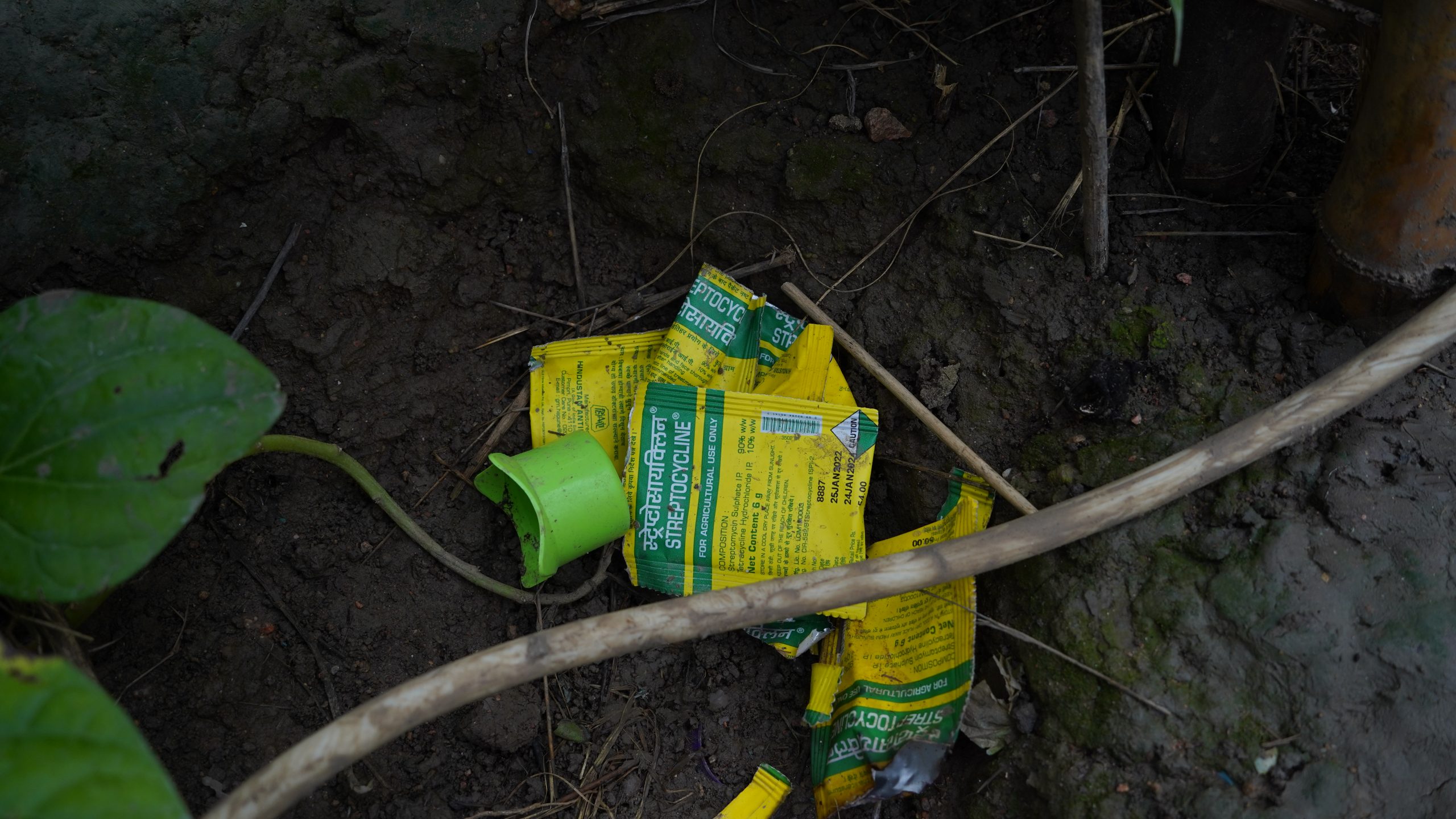 Used pesticide packets on dark mud