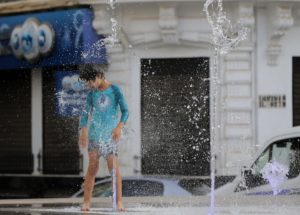 <p>2023 年 7 月，阿尔及利亚阿尔及尔市中心，一名男孩在热浪中用喷泉冲凉。图片来源：Alamy</p>