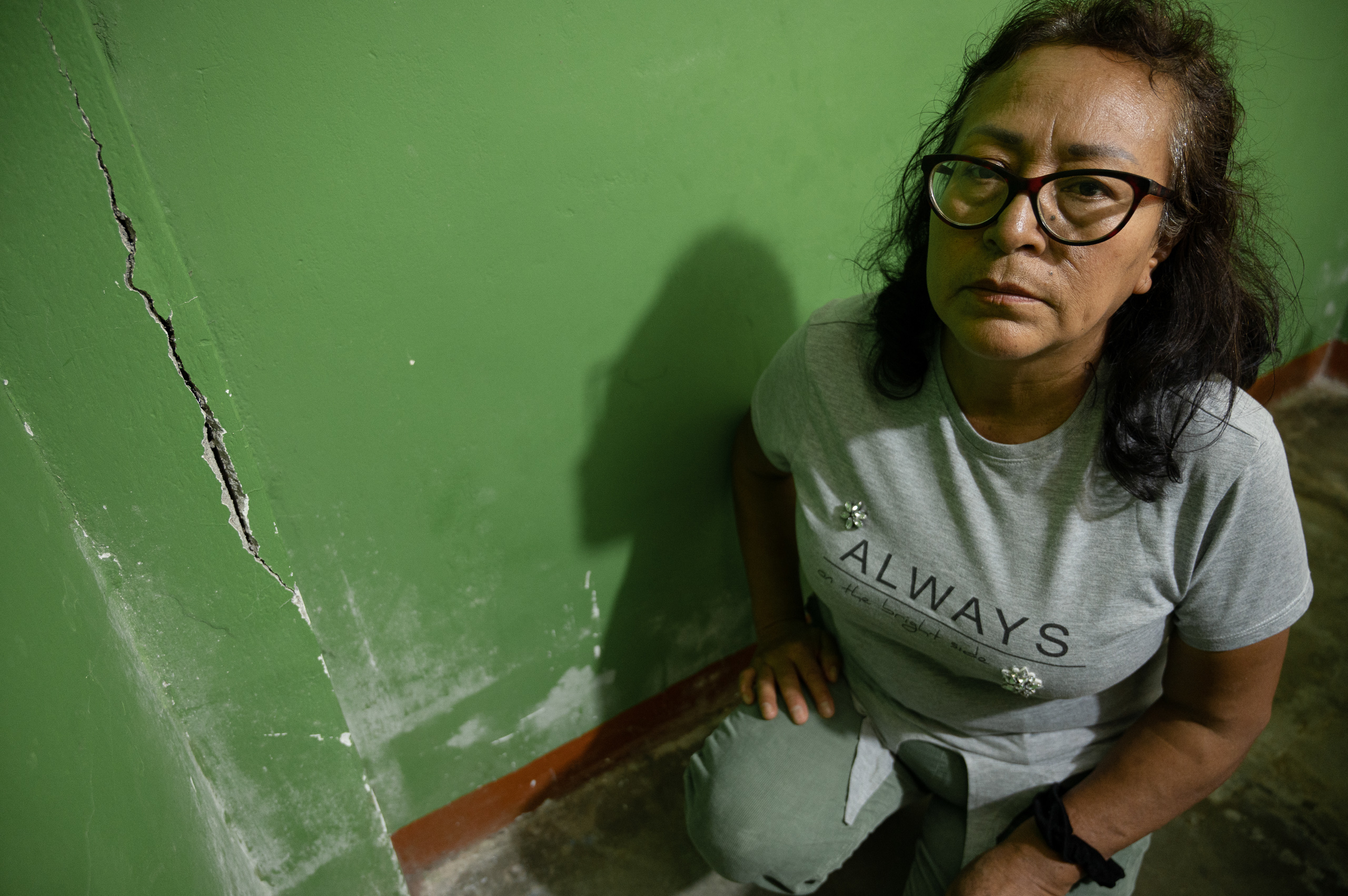 woman kneeling near cracked wall